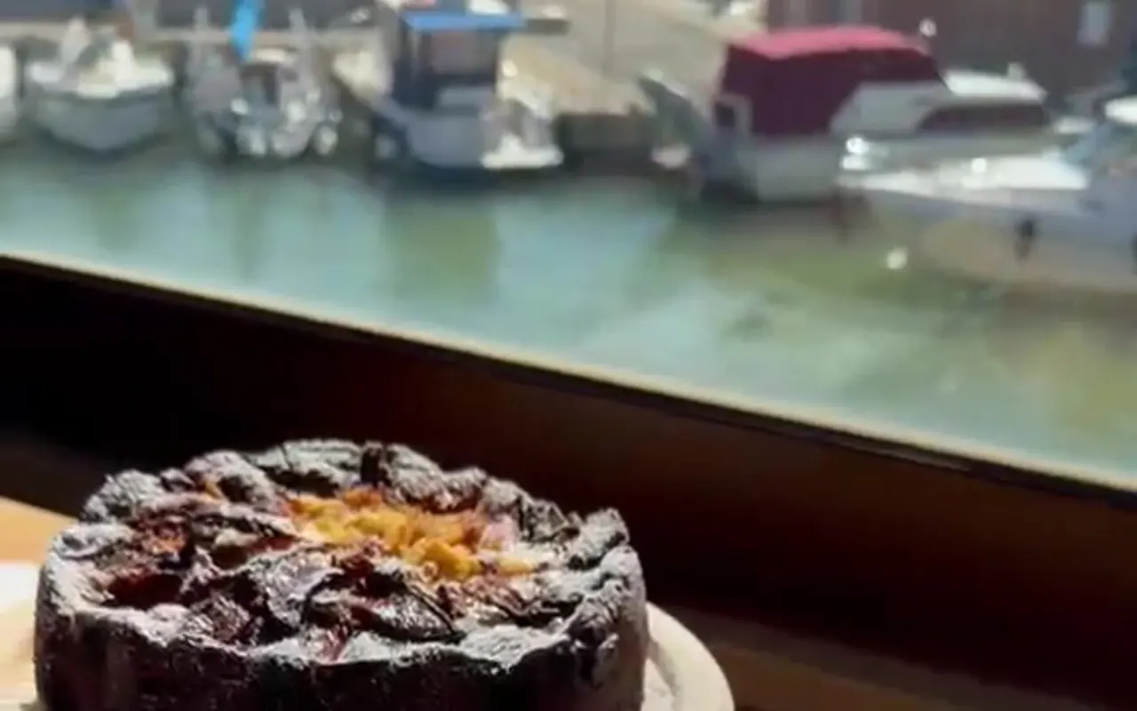 La vetrata sul porto con le barche ormeggiate e due dolci in primo piano