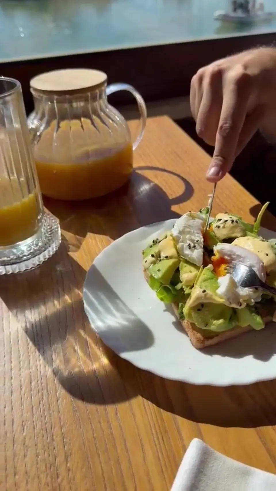 Avocado toast con uovo in camicia e caraffa di succo d'arancia